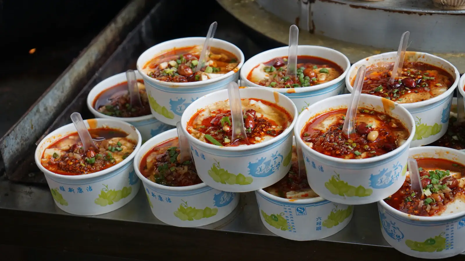 Scharfe Sichuan-Street-Food-Gerichte an einem Nachtmarktstand